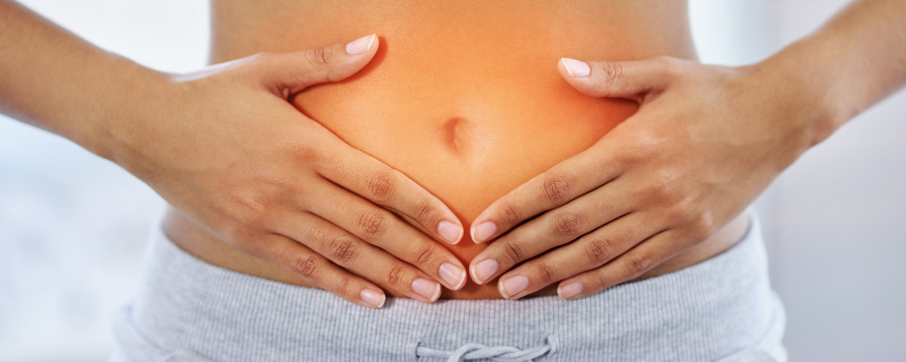 Darmgesundheit bei Frauen: Frau mit Händen an dem Bauch