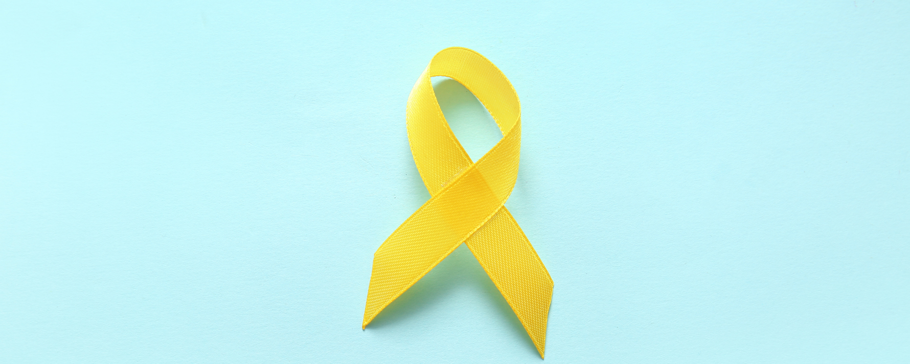 Endometriose: Gelbe Awareness-Schleife auf hellblauem Hintergrund.