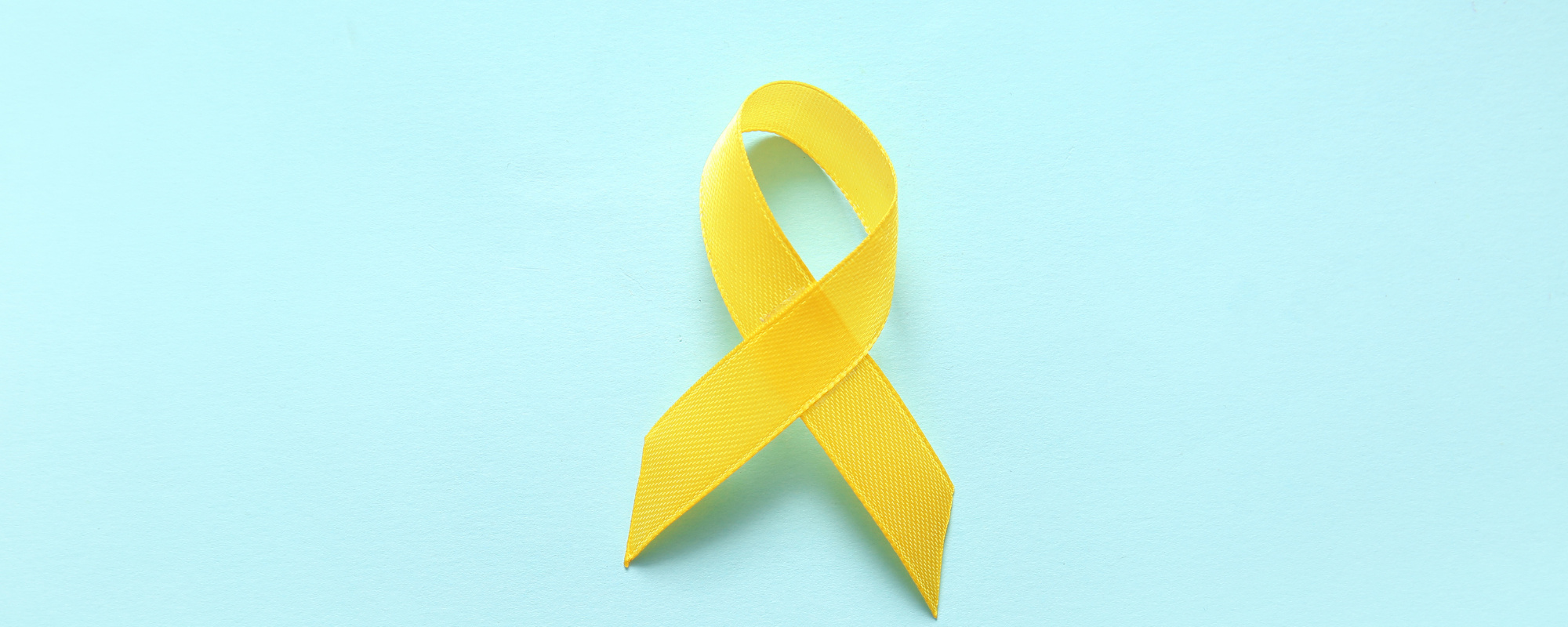 Endometriose: Gelbe Awareness-Schleife auf hellblauem Hintergrund.