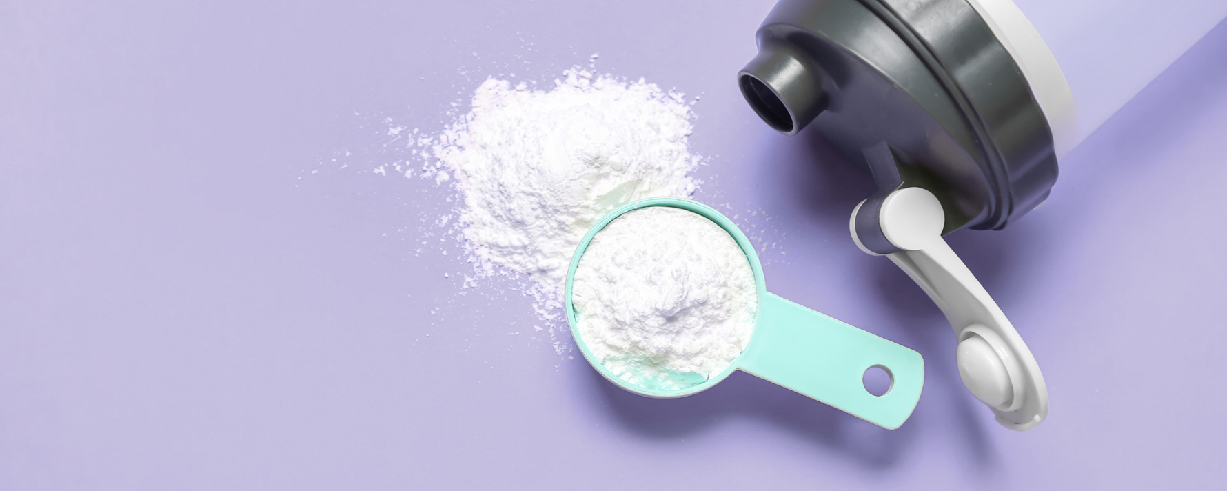 Kreatinpulver auf lila Hintergrund mit einer Trinkflasche daneben