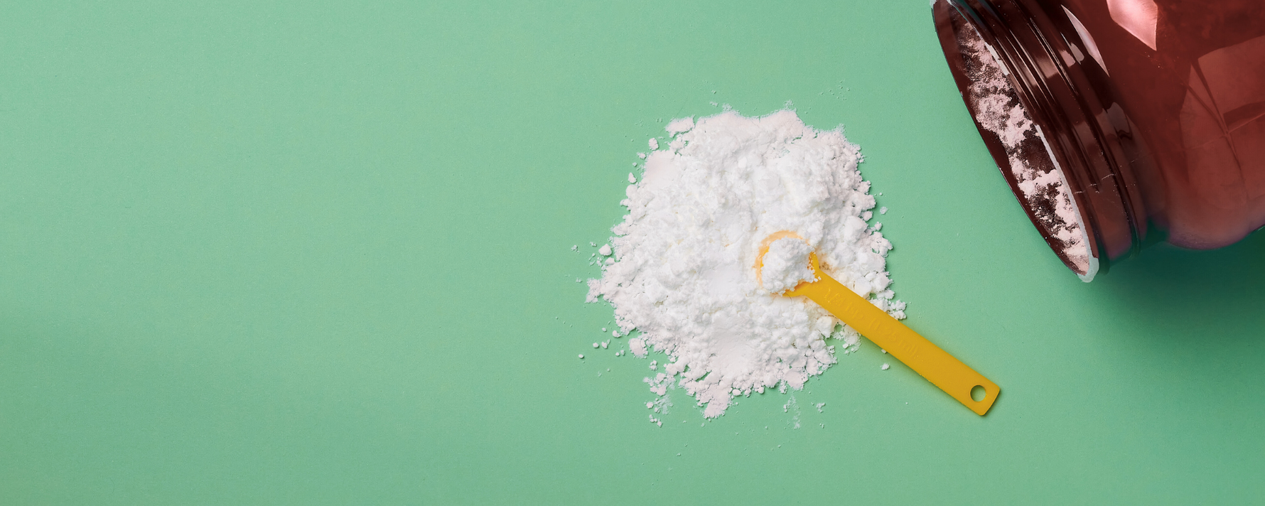 Kreatinpulver mit Dose auf einem grünem Tisch