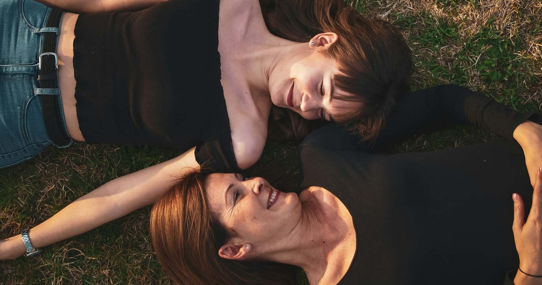 Longevity bei Frauen - Mutter und Tochter auf einer Wiese mit glücklichem Gesichtsausdruck