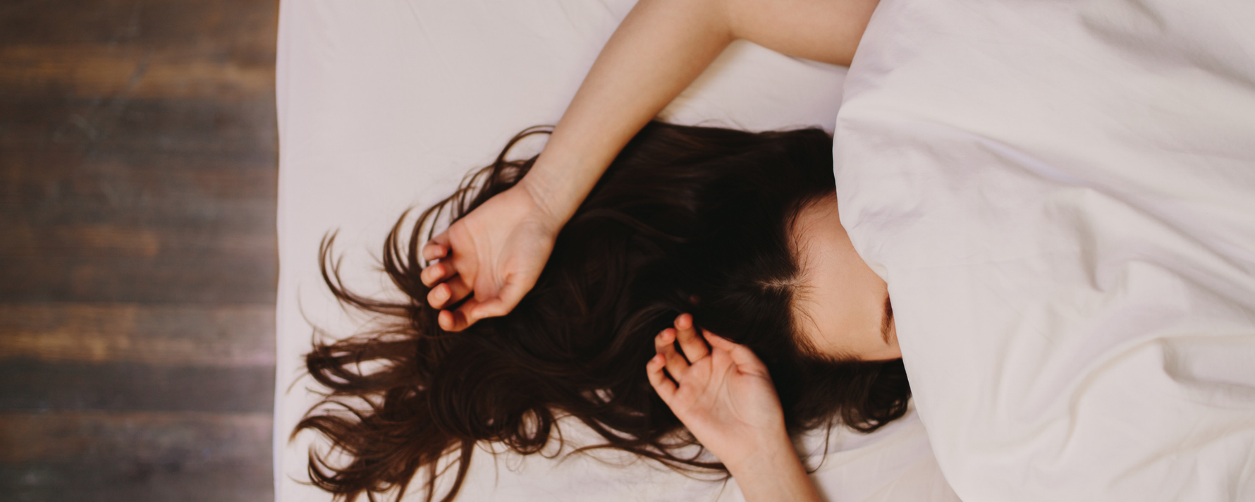 Müde Frau im Bett mit der Bettdecke über dem Gesicht