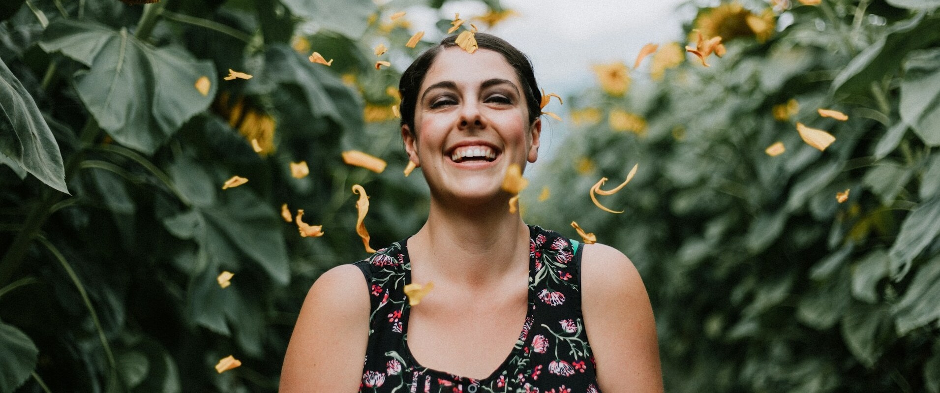 Starke, glückliche Frau inmitten von Bananenbäumen